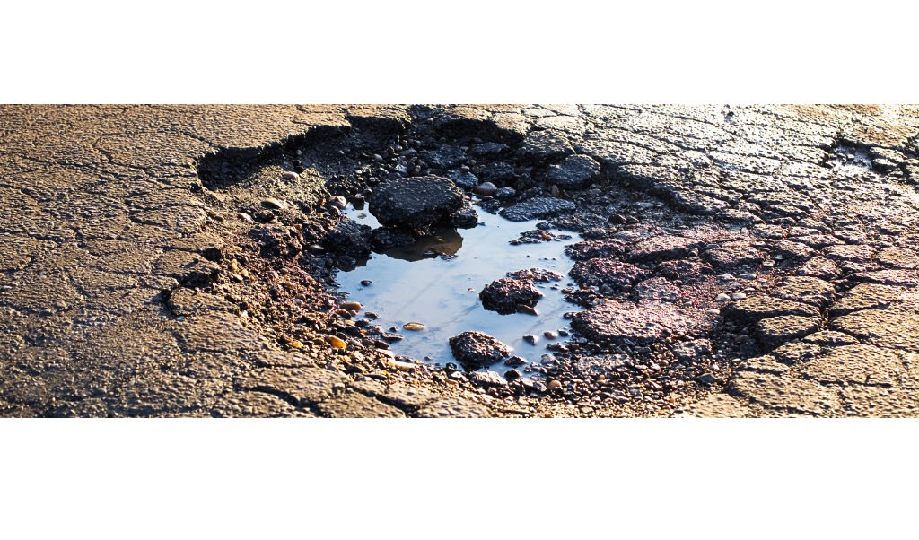 Close up image of a pothole in a tarmac road