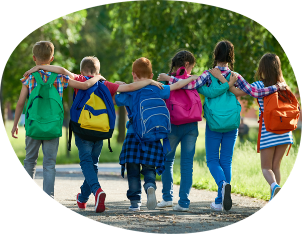 Six children walking away from camera along a park footpath with their arms around each others shoulders